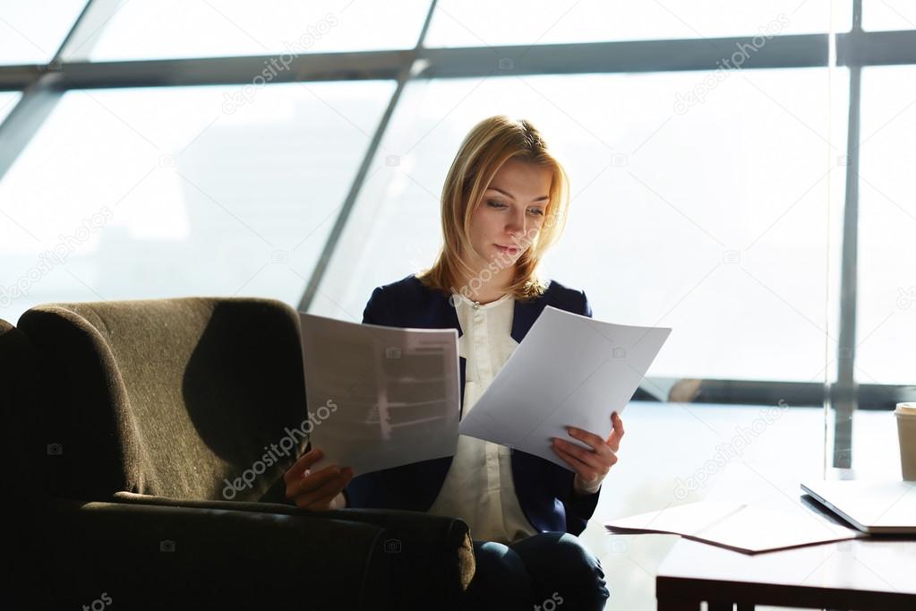 Businesswoman examining paperwork at her desk