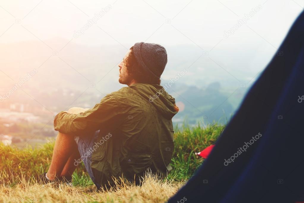 Hipster man sitting at his campsite