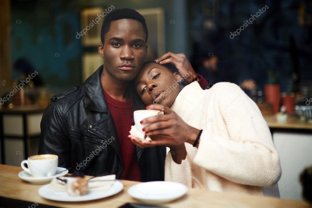 Dark skinned couple sitting in coffee shop