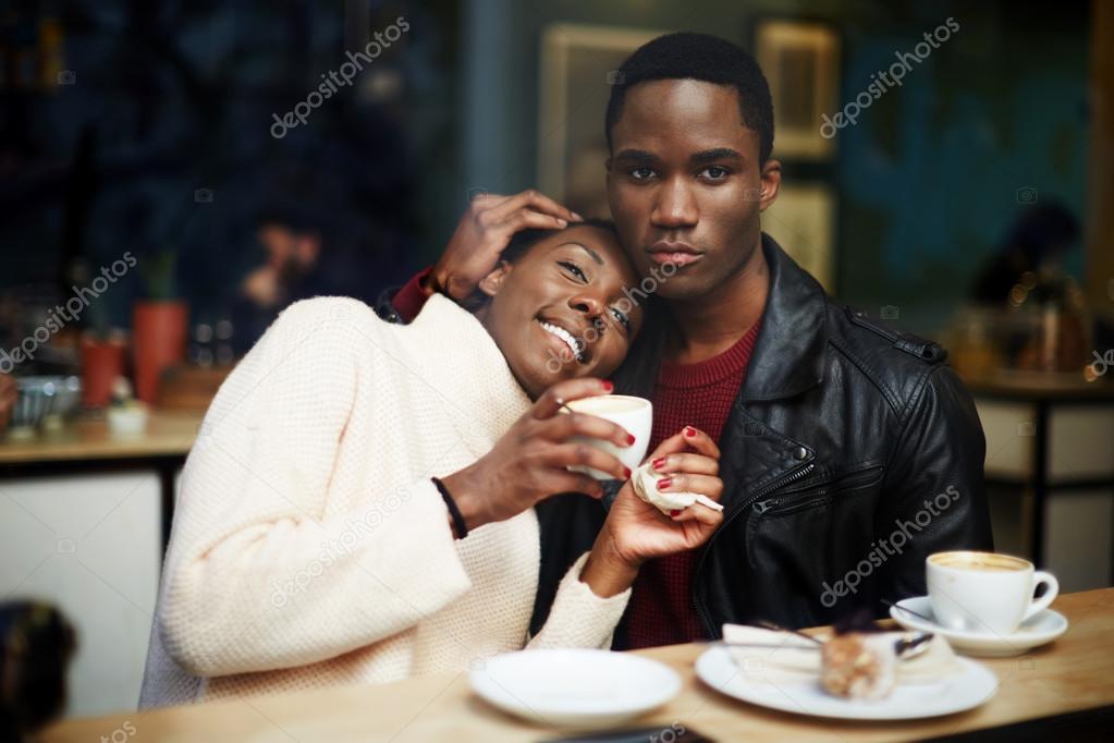 Dark skinned couple sitting in coffee shop