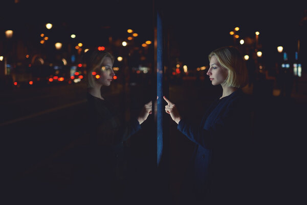 woman touching sensitive screen of smart city bus stop