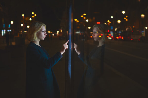 woman touching sensitive screen of smart city bus stop