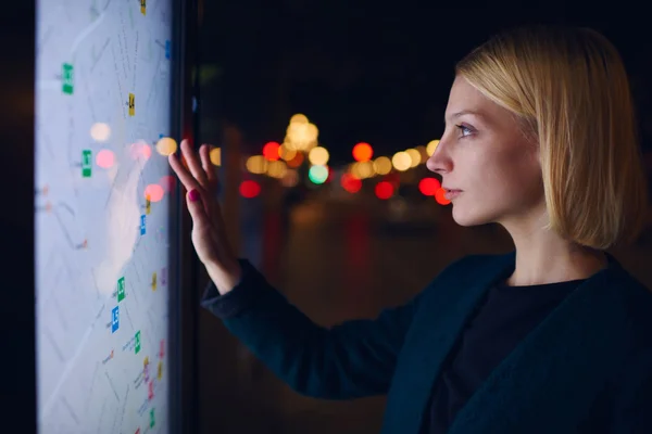 Woman standing in front of big GPS screen — ストック写真