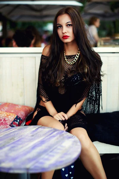 Young woman sitting outdoors in beach cafe — Stock Photo, Image