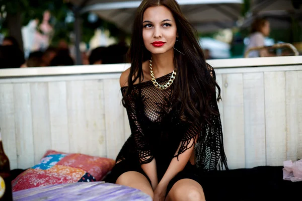 Jovem mulher sentada ao ar livre no café da praia — Fotografia de Stock