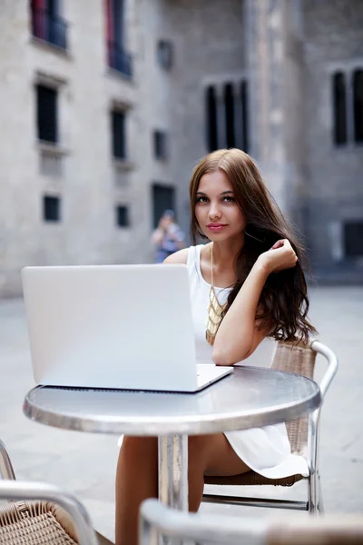 Tiener werken op haar laptop op een bistro — Stockfoto