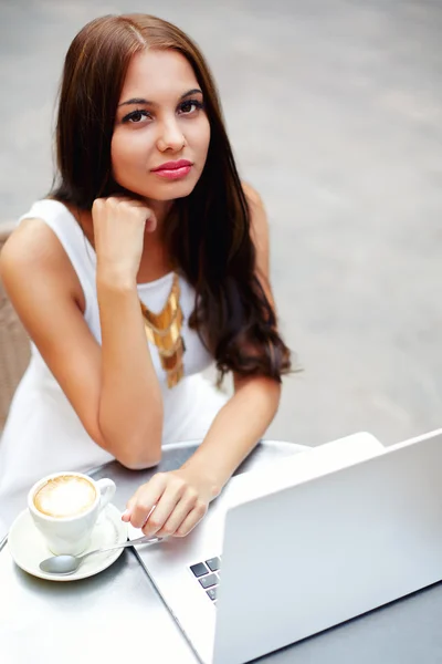 Teen working on her laptop at a bistro — Stock Photo, Image