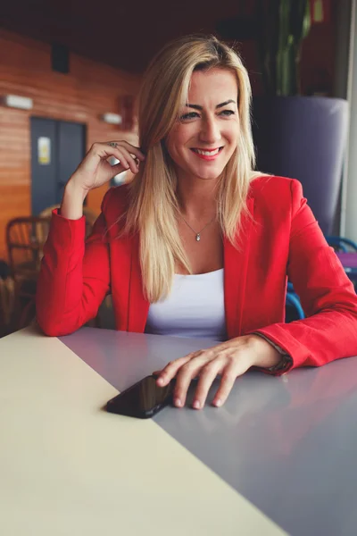 Businesswoman sitting in cafe with smartphone — Zdjęcie stockowe