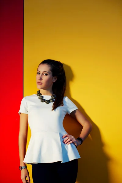 Woman posing on colored wall — Stock Photo, Image