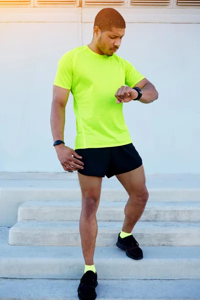 Male runner looking at his watch — Stock Photo, Image