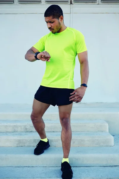 Male runner looking at his watch — Stock Photo, Image