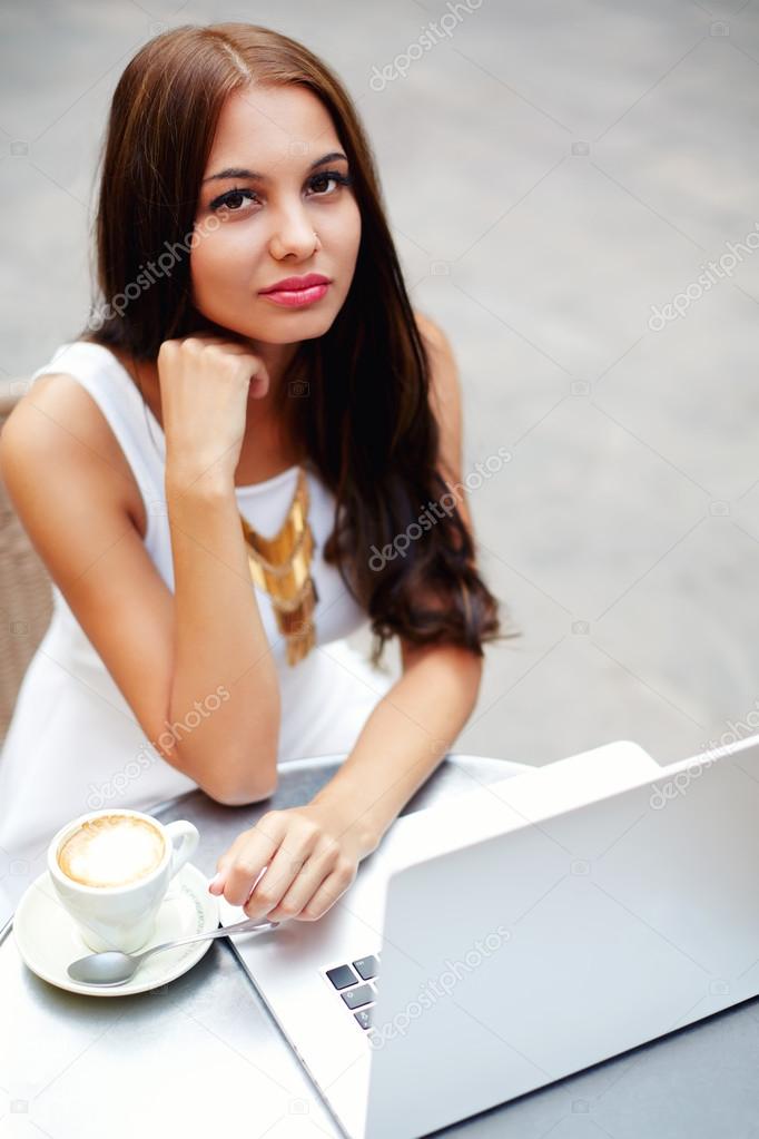 teen working on her laptop at a bistro