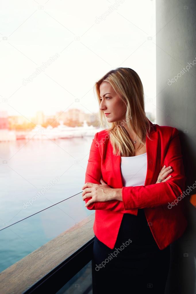 businesswoman looking out of an office balcony