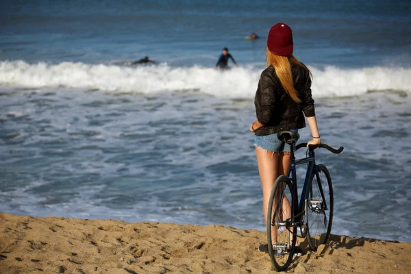 Hipster flicka avkopplande på stranden wit cykel — Stockfoto