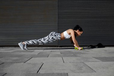 kadının basın yapması dumbbells ile ups