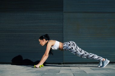 kadının basın yapması dumbbells ile ups