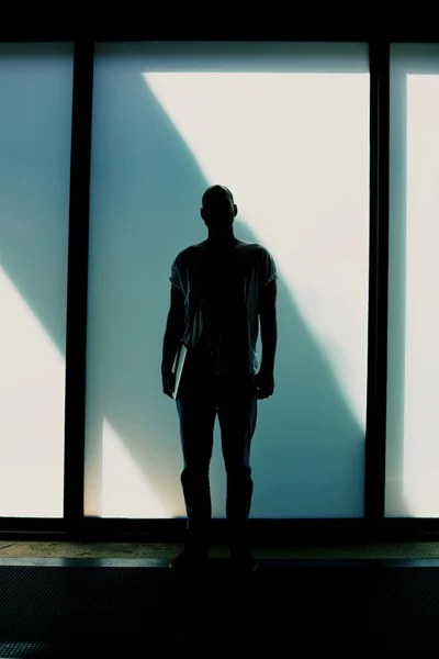 Silhouette of young man standing with laptop — Stock Photo, Image