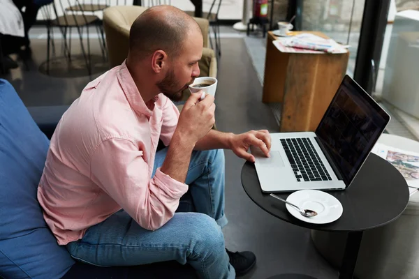 Businessman near laptop drinking coffee — Stock Photo, Image