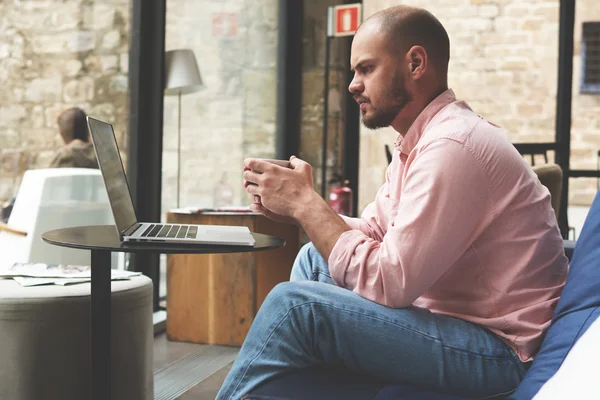 Arbetar man med kopp kaffe — Stockfoto