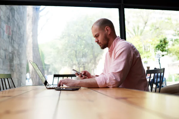 Student sitting at wooden table with laptop — Stock Photo, Image