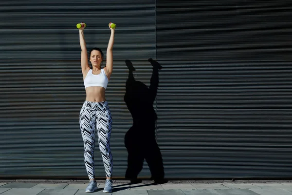 Mulher durante o treinamento com dumbles — Fotografia de Stock