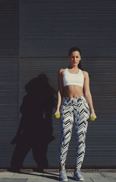 Young woman holding weights in hands — Stock Photo, Image