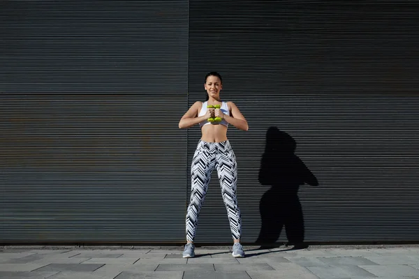 Woman using dumbbells to work out — Stock Photo, Image