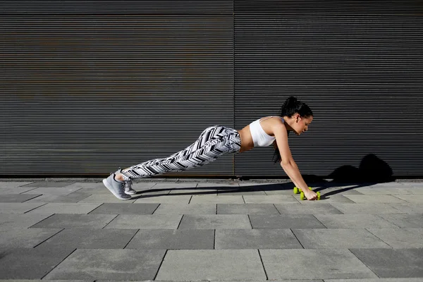 Mulher fazendo press ups com halteres — Fotografia de Stock