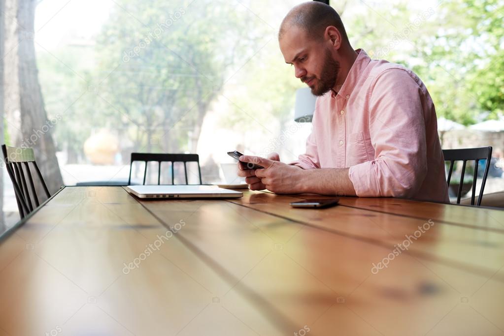 student sitting at wooden table with laptop