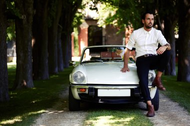 lüks cabriolet kaputa oturan adam
