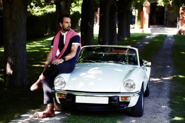 lüks cabriolet kaputa oturan adam