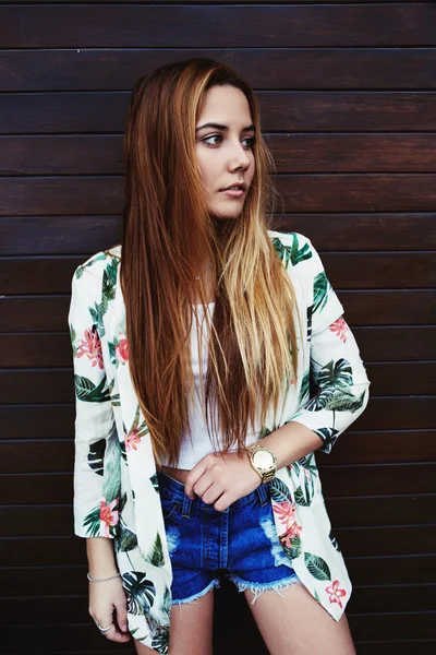 Mladá žena stojící dřevěné zdi — Stock fotografie