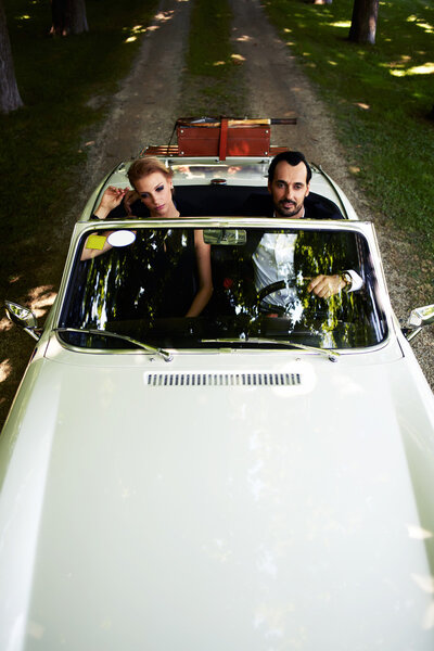 богатая и известная пара, сидящая в кабриолете
