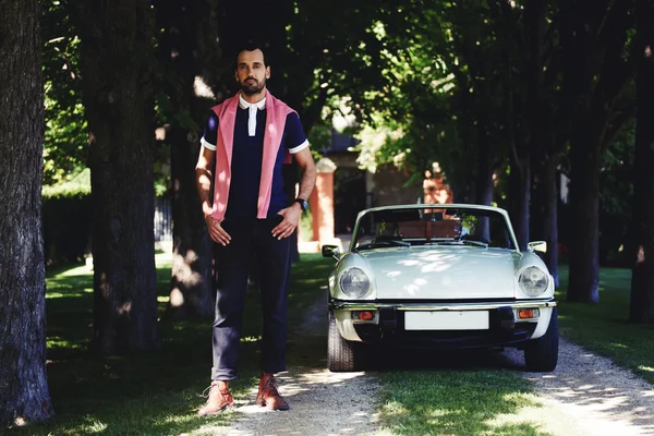 Handsome man standing against luxury car — Stock Photo, Image