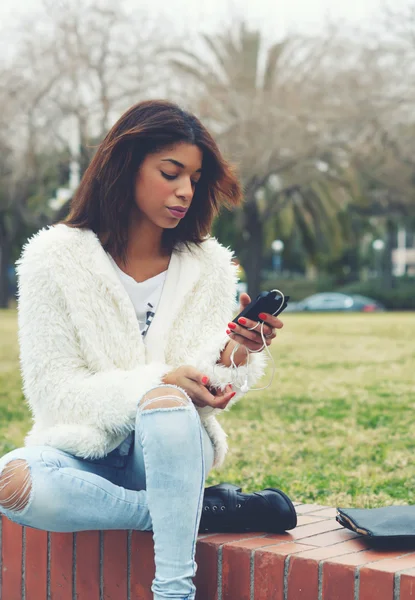 Hipster holding smart phone in park — Stock Photo, Image