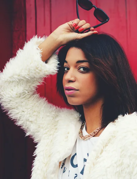 Afro american woman posing on red wall — Stock Photo, Image