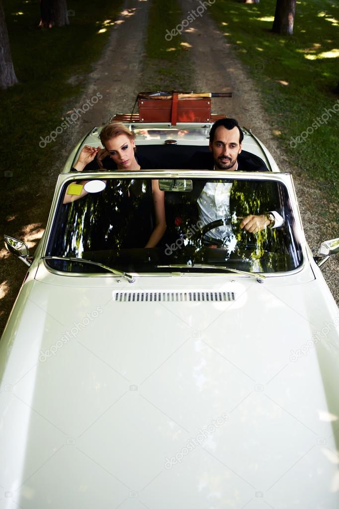wealthy and famous couple sitting inside cabriolet