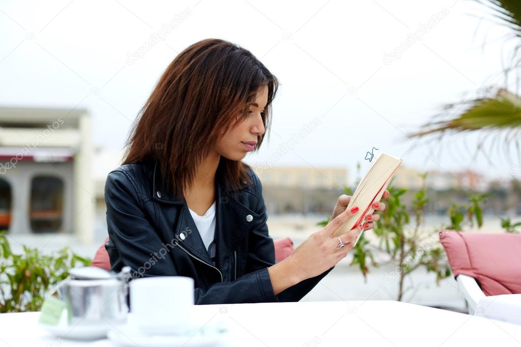 Charming woman with book in restaurant