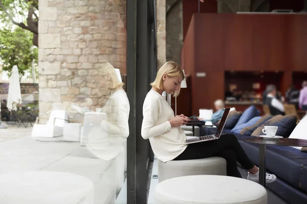 Female freelancer connecting to wireless in cafe — Φωτογραφία Αρχείου