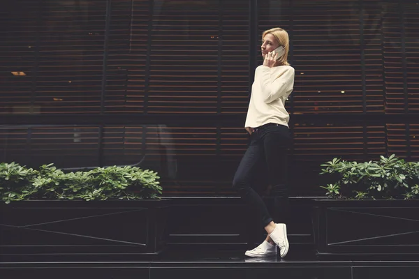 Chica de pie en la ciudad y hablando en su teléfono inteligente — Foto de Stock