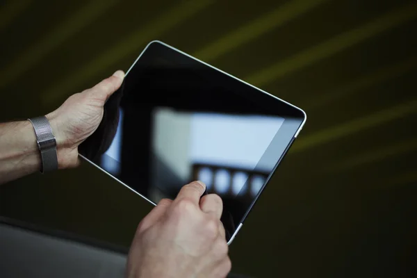 Cropped shot of male person holding digital tablet with beautiful reflection on the screen — Stock Photo, Image