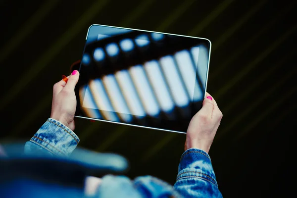 The girl dressed in a denim jacket holding a tablet — Stock Photo, Image
