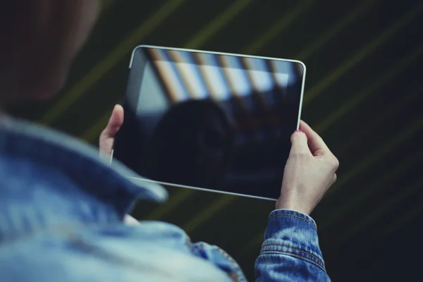 La ragazza vestita con una giacca di jeans che tiene un tablet — Foto Stock