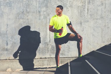 runner holding bottle of energy drink