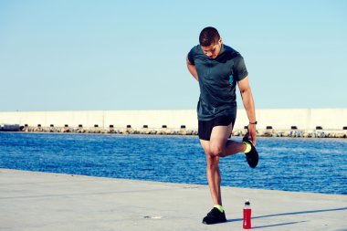 Male runner stretching legs