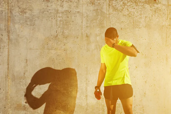 Musculoso construir hombre frotando su frente — Foto de Stock