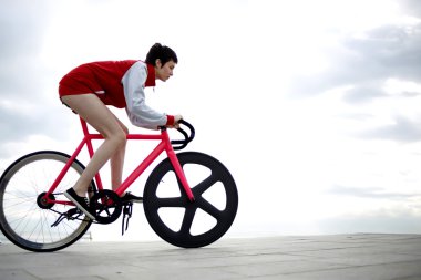 stylish young woman riding on bicycle