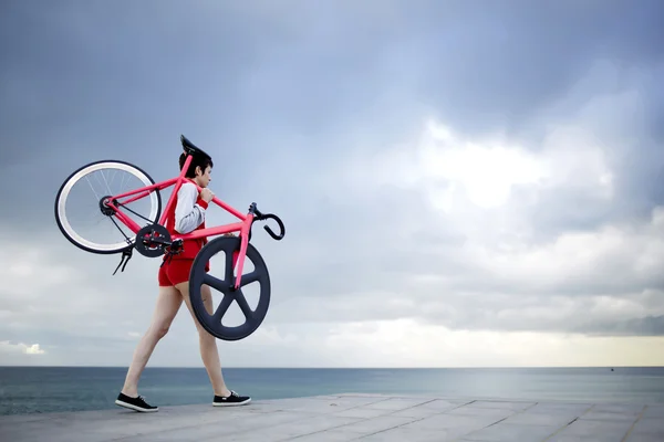 Woman holding her light weight bike — Stockfoto