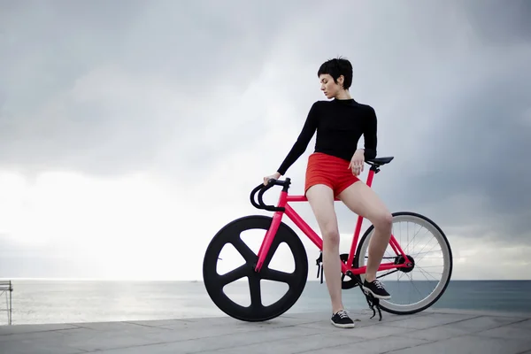 Mulher hipster elegante com sua bicicleta esportiva — Fotografia de Stock