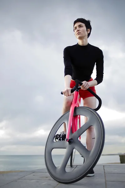 Молодая спортивная женщина позирует со своим велосипедом — стоковое фото